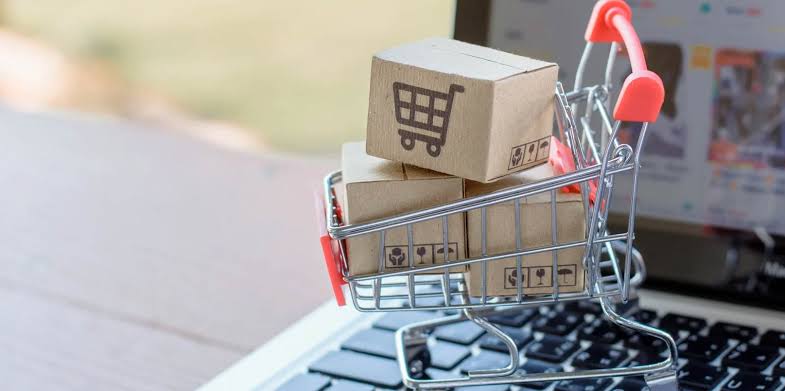 Mini shopping cart filled with parcels on a laptop keyboard, representing online orders and the need to preserve receipts, tracking details, and payment evidence after a marketplace closes.